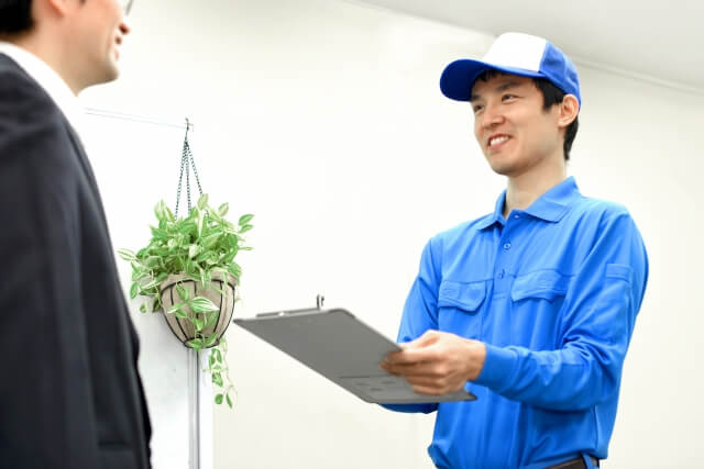 配達員が笑顔で書類確認を行う