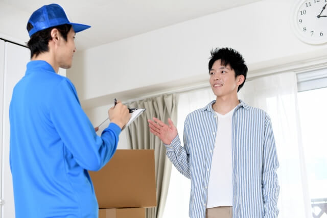 荷物を受け取る男性と配達員