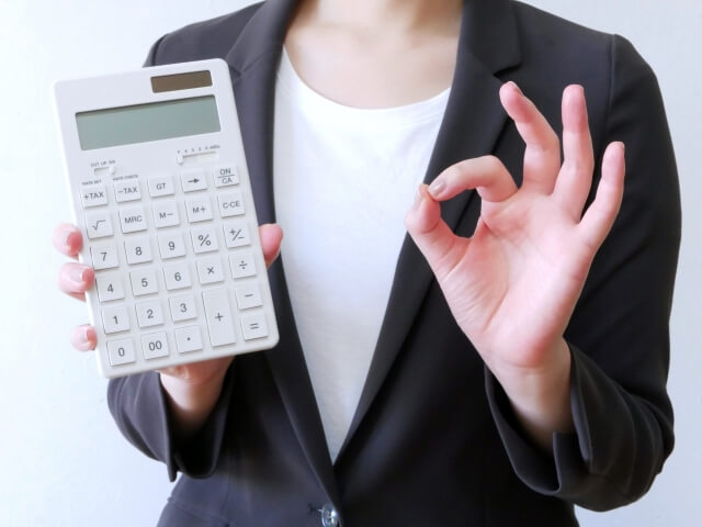 計算機を持ち親指を立てる人