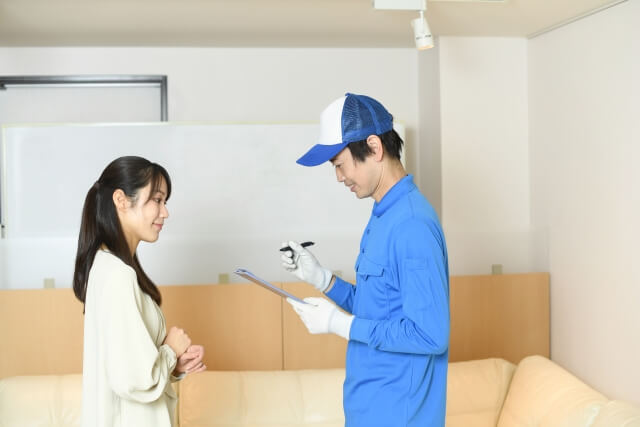 荷物を確認する作業員と女性